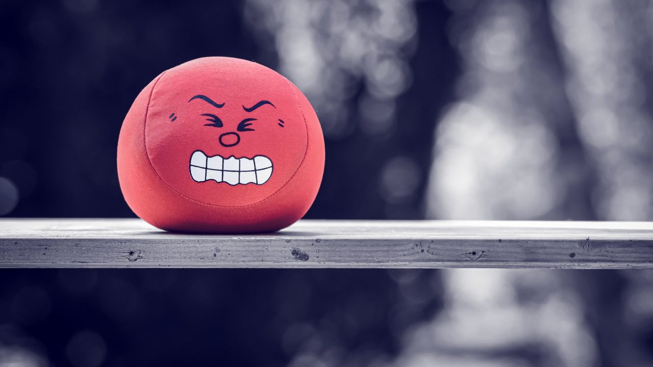 Egy piros labda egy padon, amin egy dühös/ideges arc van.