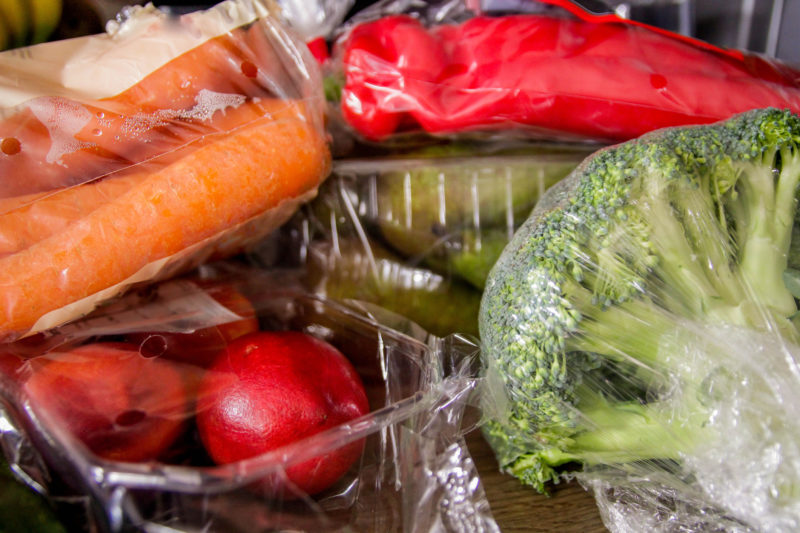 Műanyagba csomagolt zöldségek, gyümölcsök hűtőszekrényben