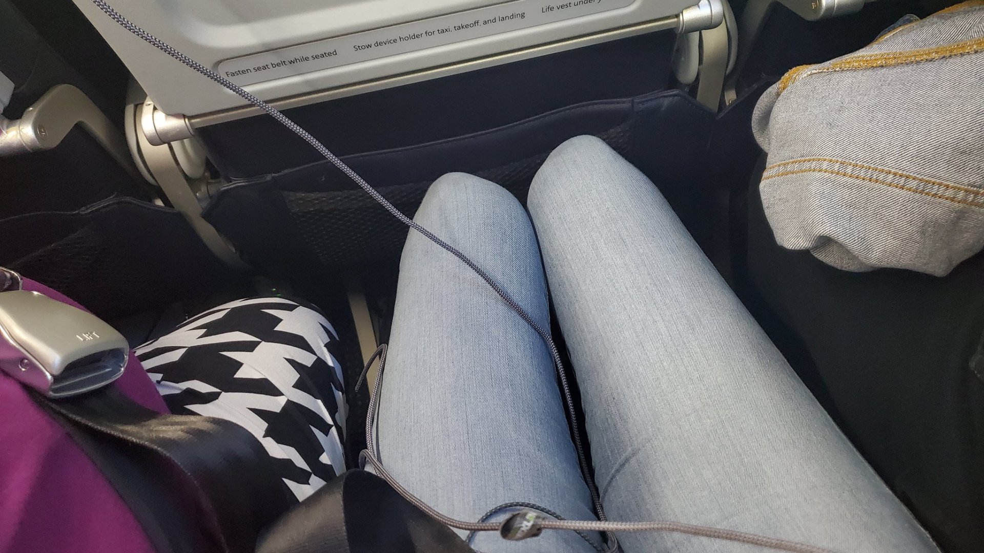 Egy nő összetett lába két túlsúlyos utas között a repülőn