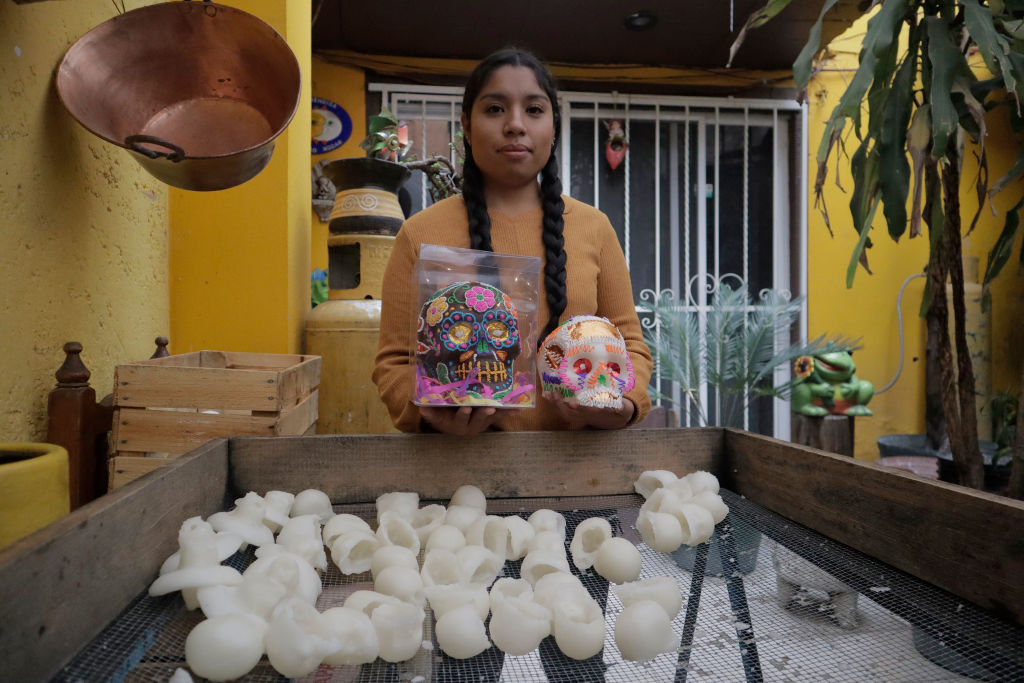 Mexikói halottak napja: csokoládé- és cukorkakoponya egy édességkészítő lány kezében