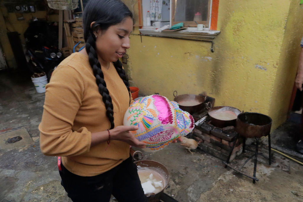 Mexikói halottak napja: cukorkakoponya egy édességkészítő lány kezében