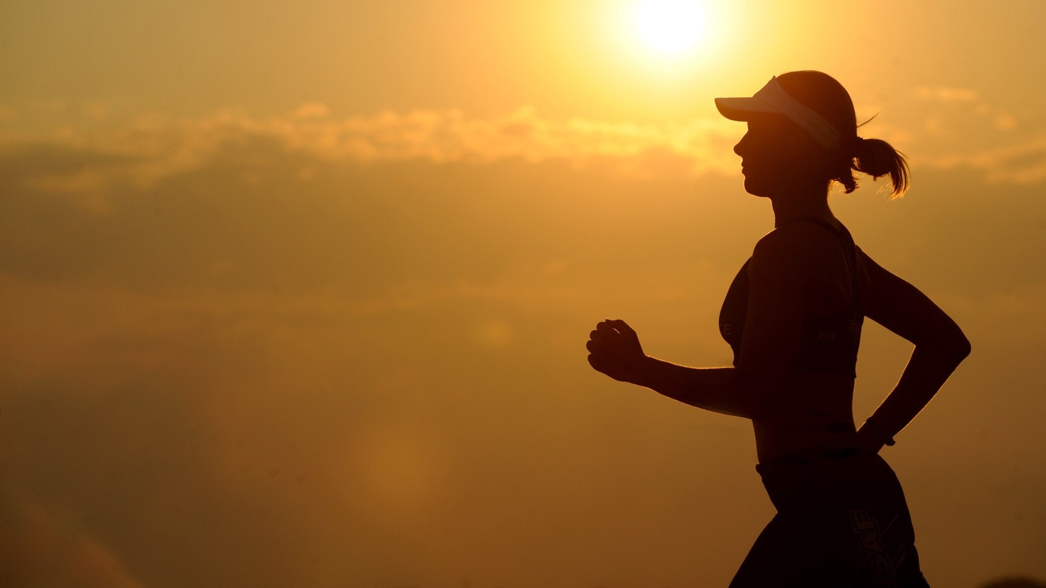 Egy nő fut a naplementében