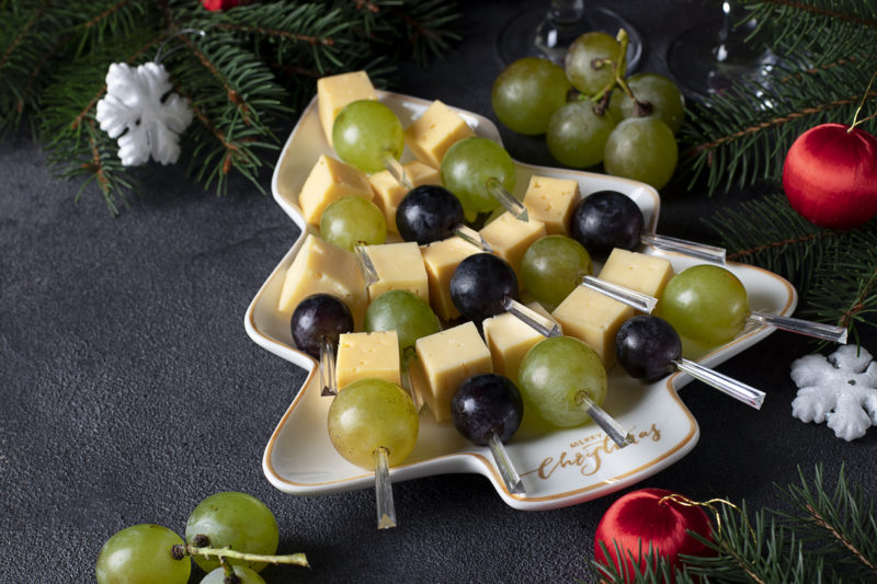 Karácsonyfa alakú kínálótányérban sajt és szőlő falatkák