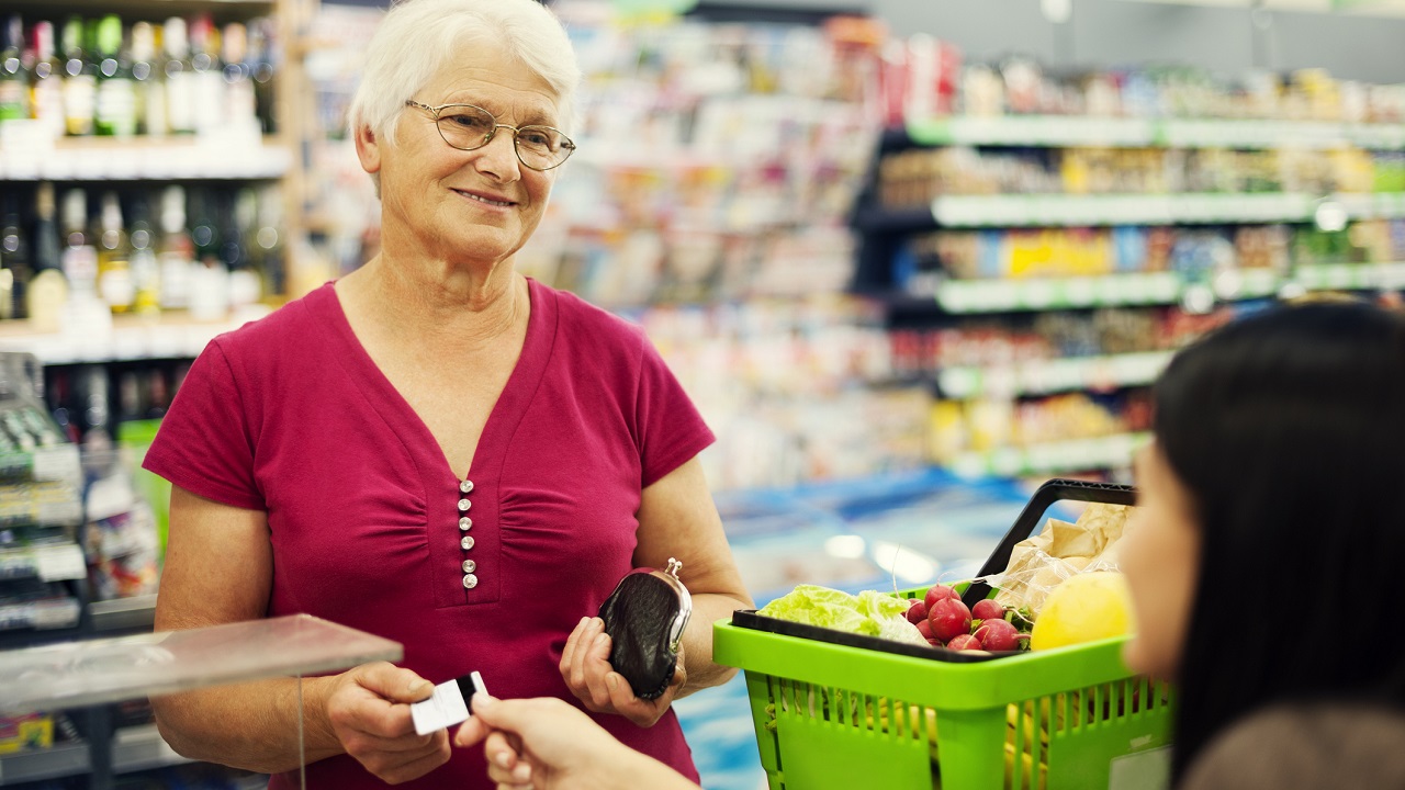Idős nő szupermarketben fizet