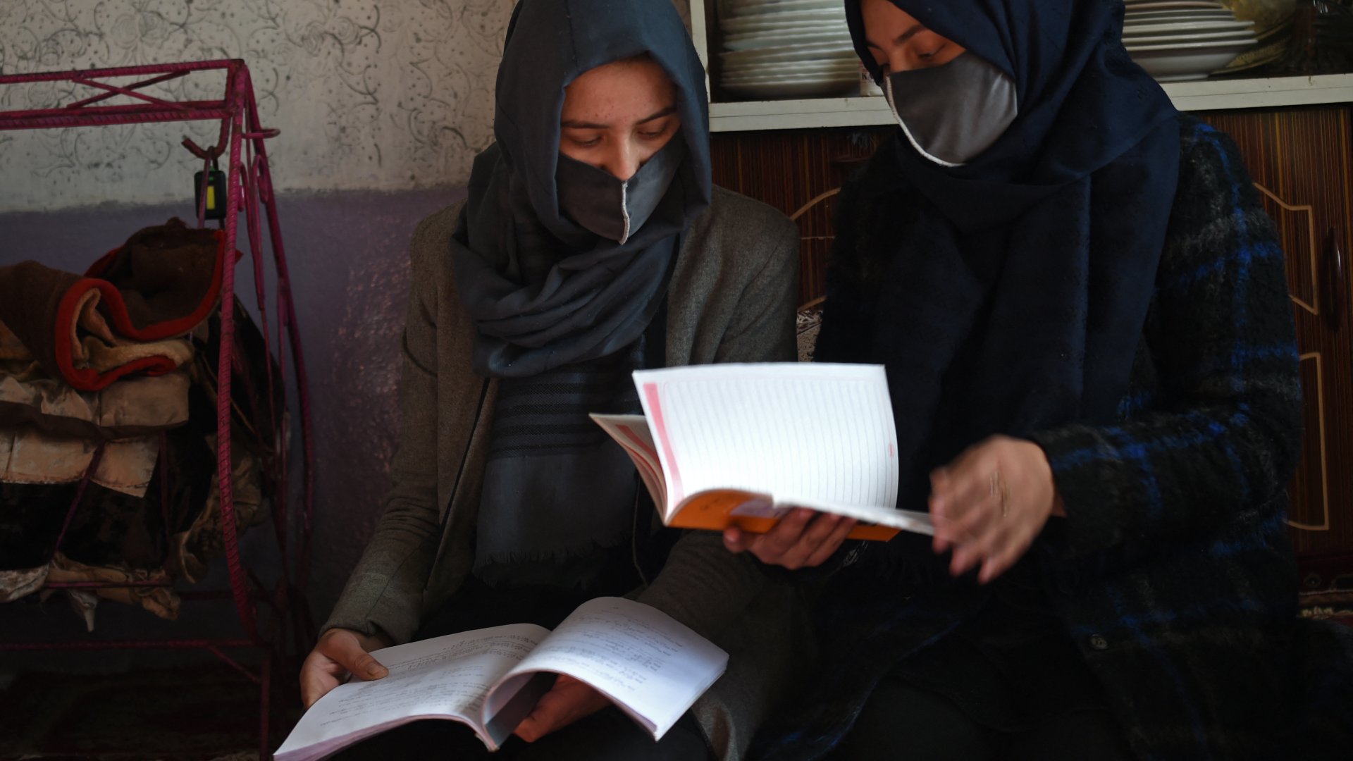 A 2022. december 23-án készült képen Marwa (balra), egy diáklány könyvet olvas a húgával otthonukban Kabulban. Marwa csak néhány hónapra volt attól, hogy családjában ő legyen az első nő, aki egyetemre mehet – ehelyett fájdalmasan nézi majd, ahogy a bátyja nélküle tanul majd