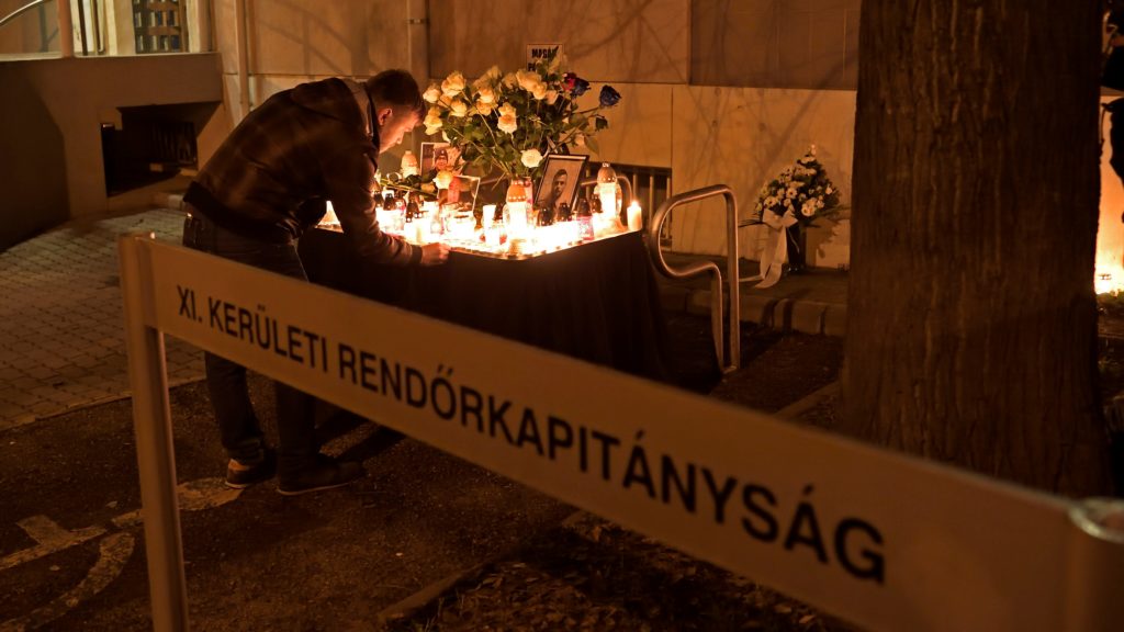 Mécsest helyez el egy férfi Baumann Péter szolgálatteljesítés közben elhunyt rendőr fotóinál az újbudai rendőrkapitányságnál tartott megemlékezésen 2023. január 13-án