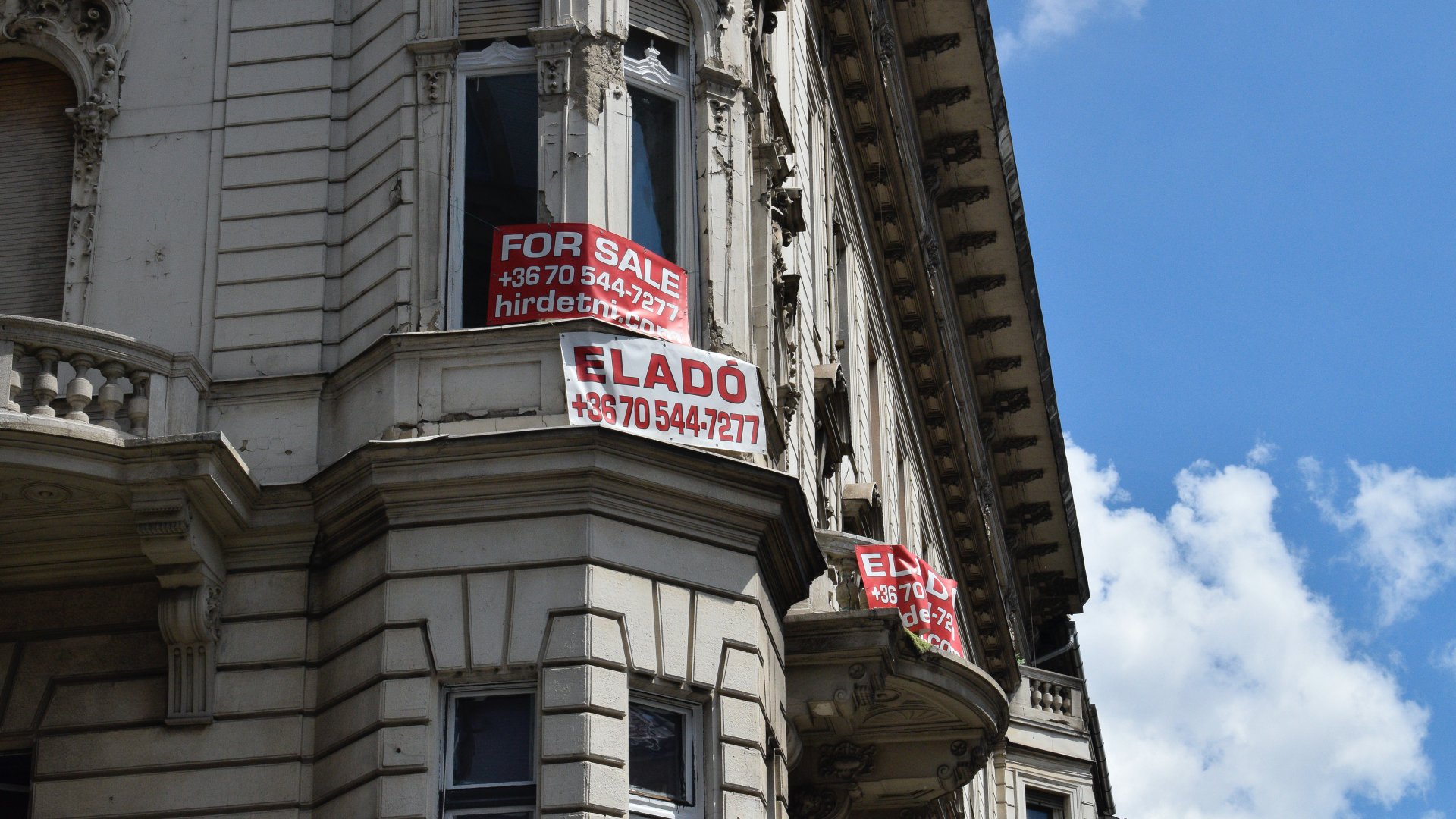 Eladó lakást hirdetõ feliratok a Kossuth Lajos és a Városház utca saroképületén