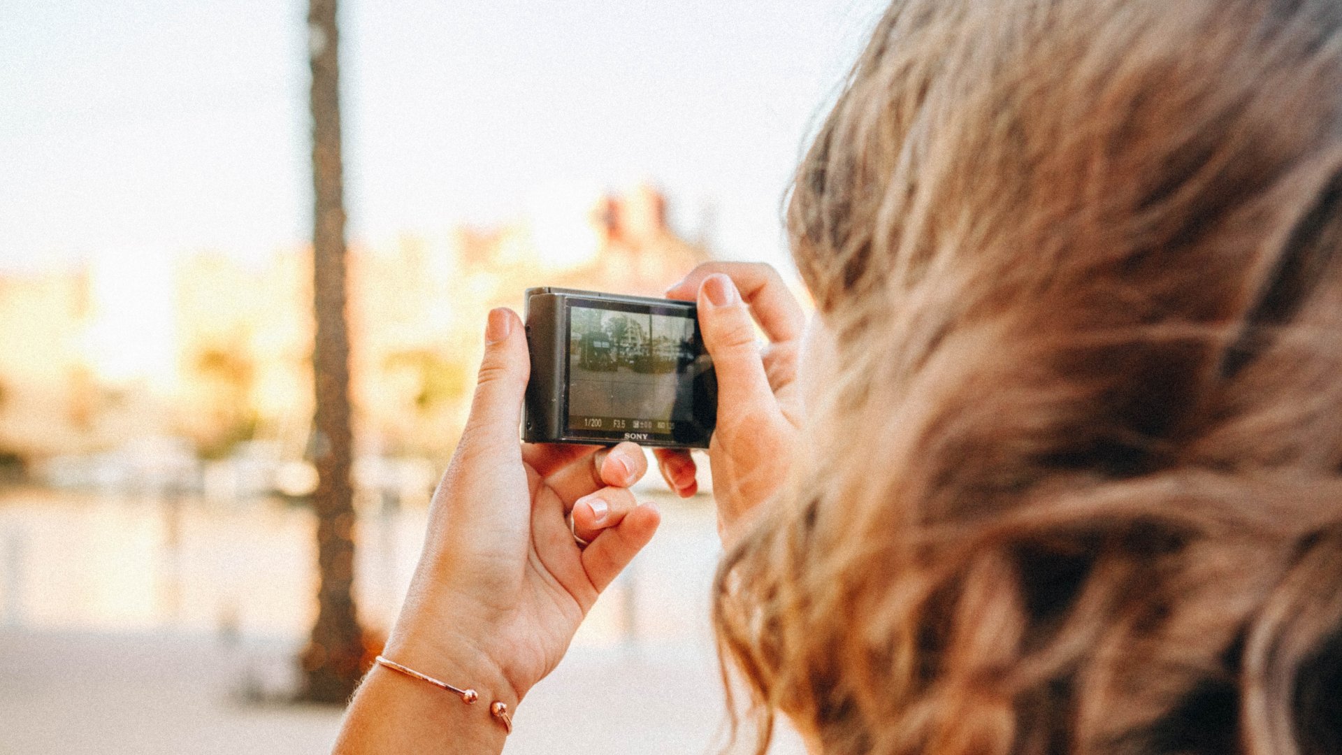 Egy nő fényképez egy kis digitális kamerával