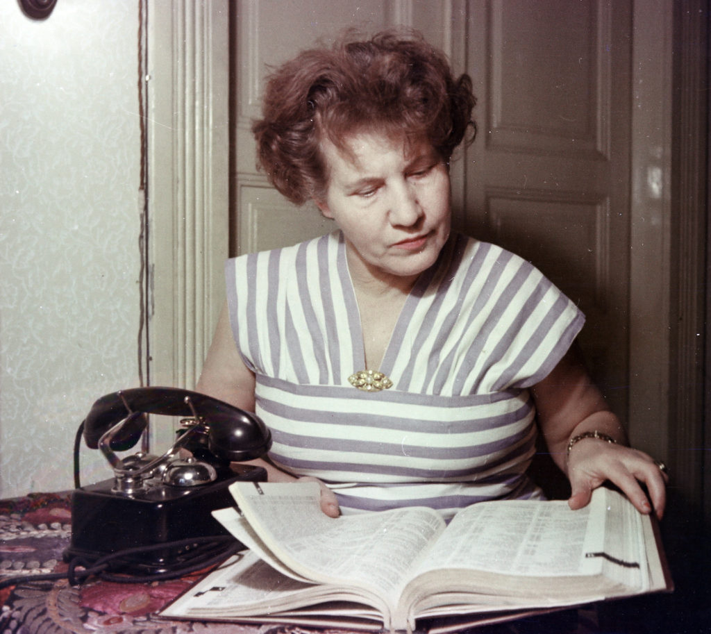 A XIII. kerületi Bulcsú utca egyik lakója lapozza a telefonkönyvet, 1955. (Fotó: Ungváry Rudolf/Fortepan)