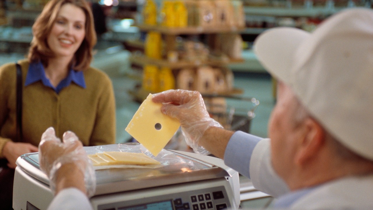 Egy eladó sajtot mér ki.