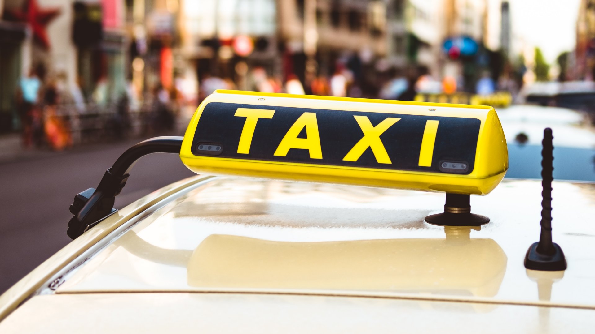 Taxijelzés egy autón a városban