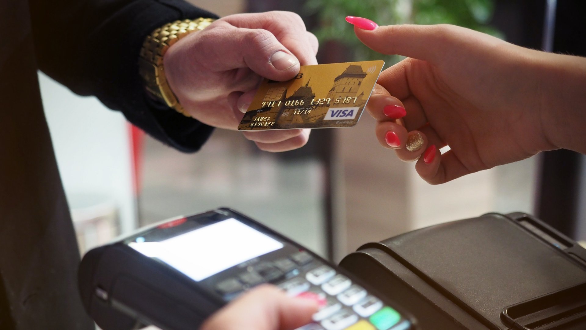 Bankkártyával fizet egy férfi a boltban