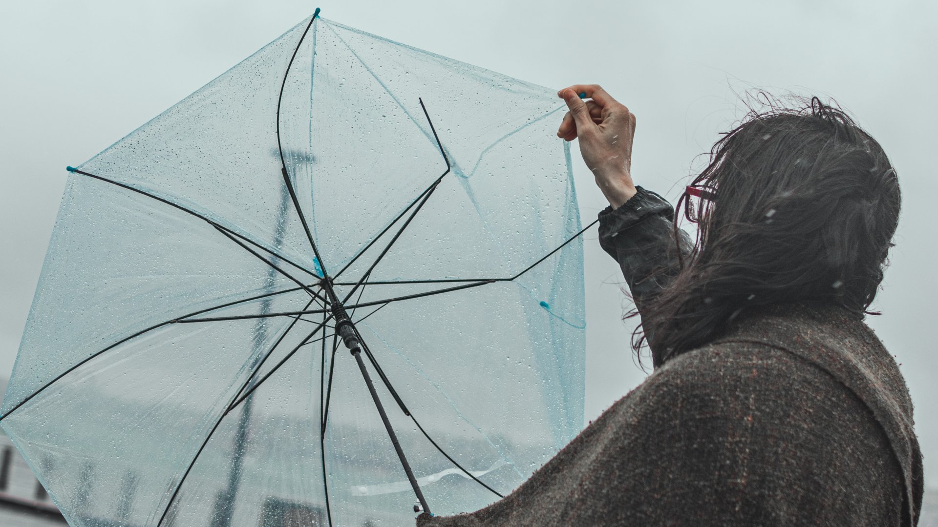 Megsérült esernyővel egy nő a viharban