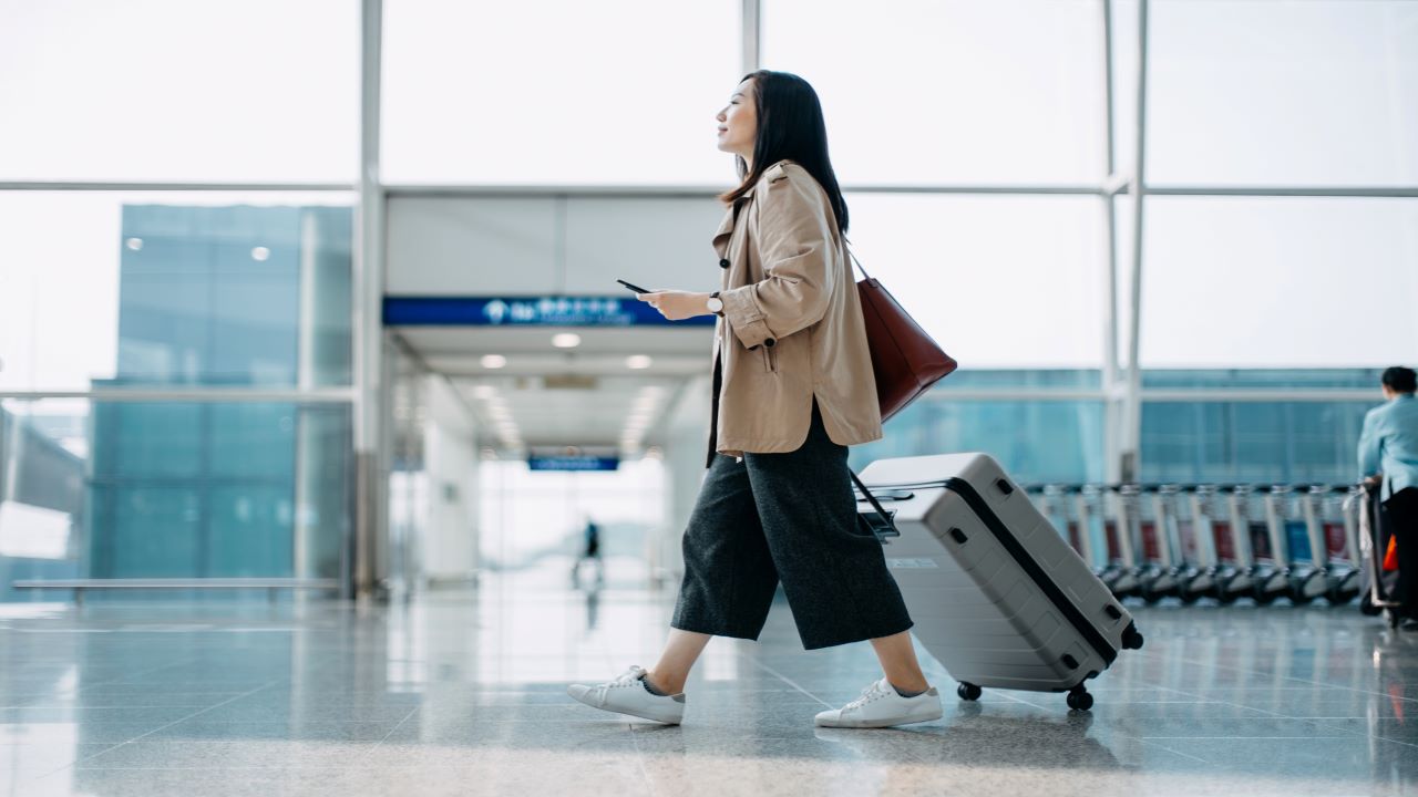 Egy nő sétál a hongkongi repülőtéren