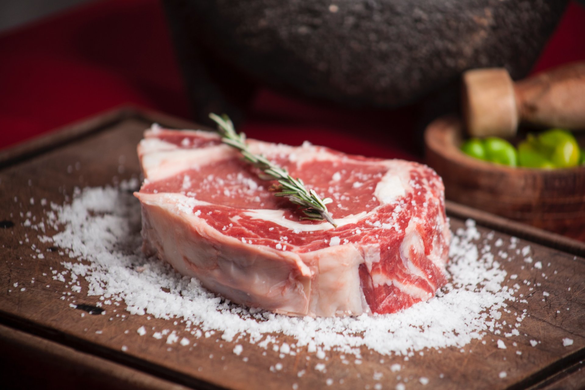 Vastag szelet steak a vágódeszkán sóval körülszórva