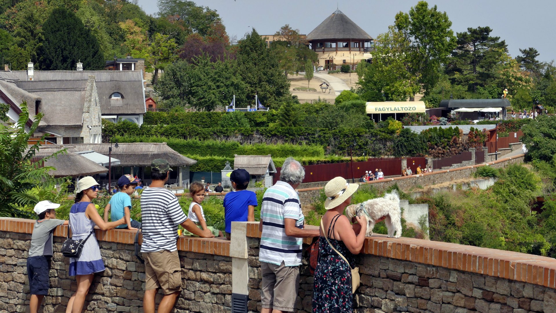 Turisták és kirándulók nézik a Balaton keleti medencéjét, valamint a település építészeti és táji szépségeit a Pisky sétányról