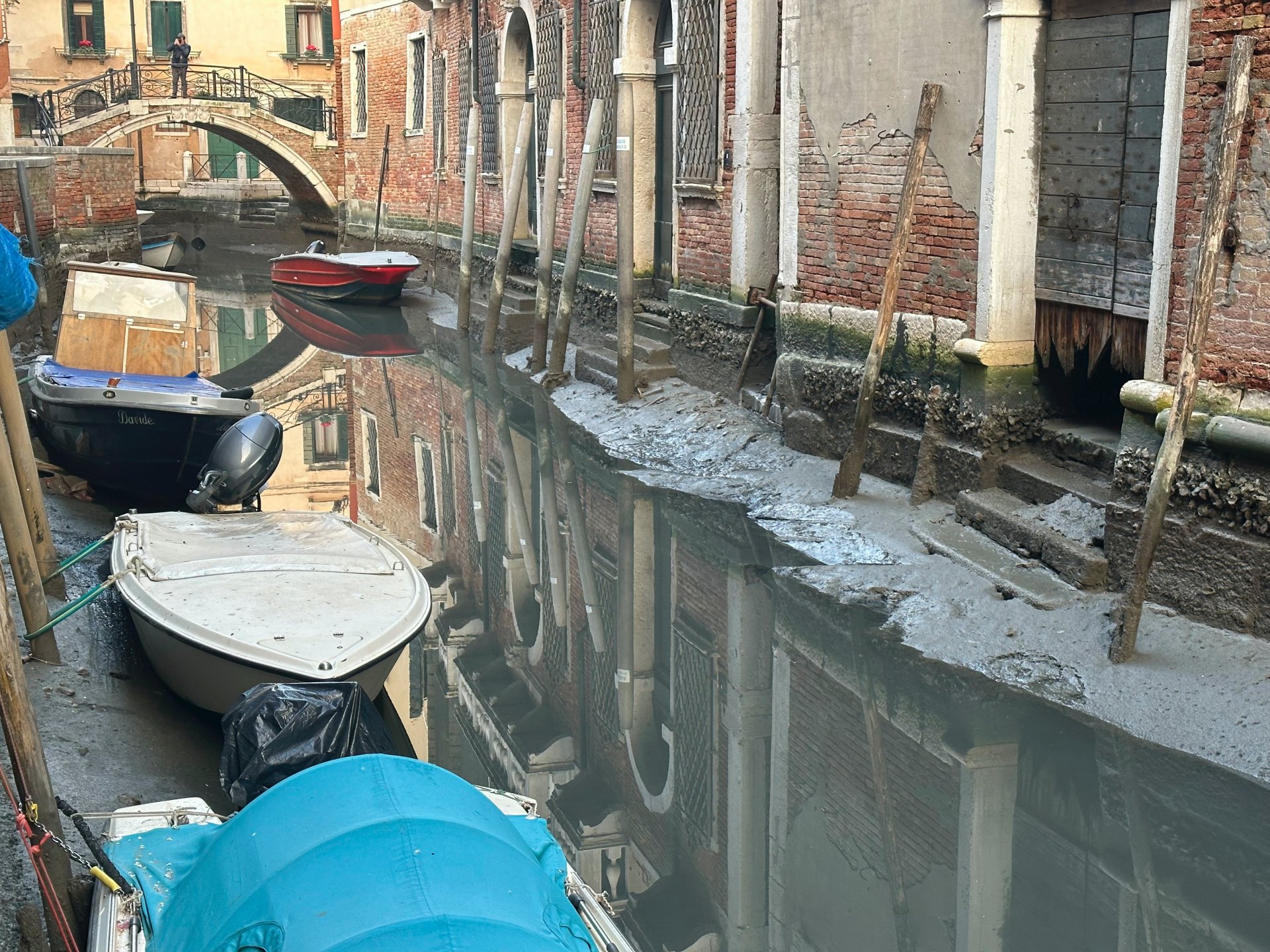 Csónakok vesztegelnek egy csaknem teljesen kiszáradt velencei csatornában 2023. február 20-án