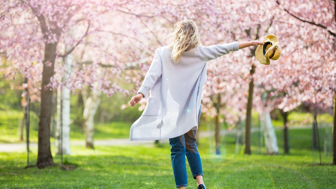 LÁny táncol a tavaszi virágzó fák alatt