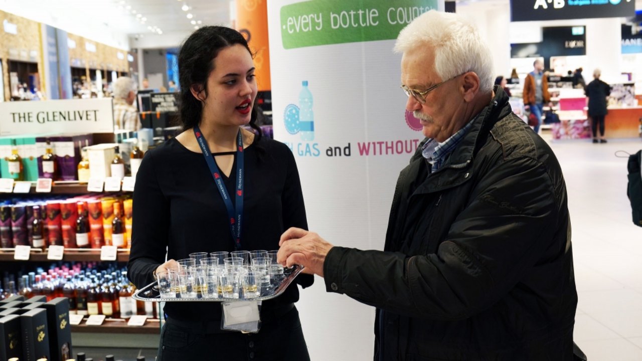 Pálinkát kóstol egy külföldi a Liszt Ferenc Nemzetközi Repülőtéren az Agrármarketing Centrum pálinkanépszerűsítő kampányában