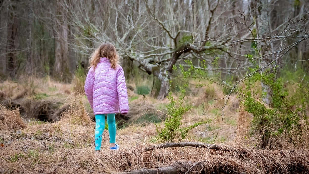 Kislány az erdőben sétál