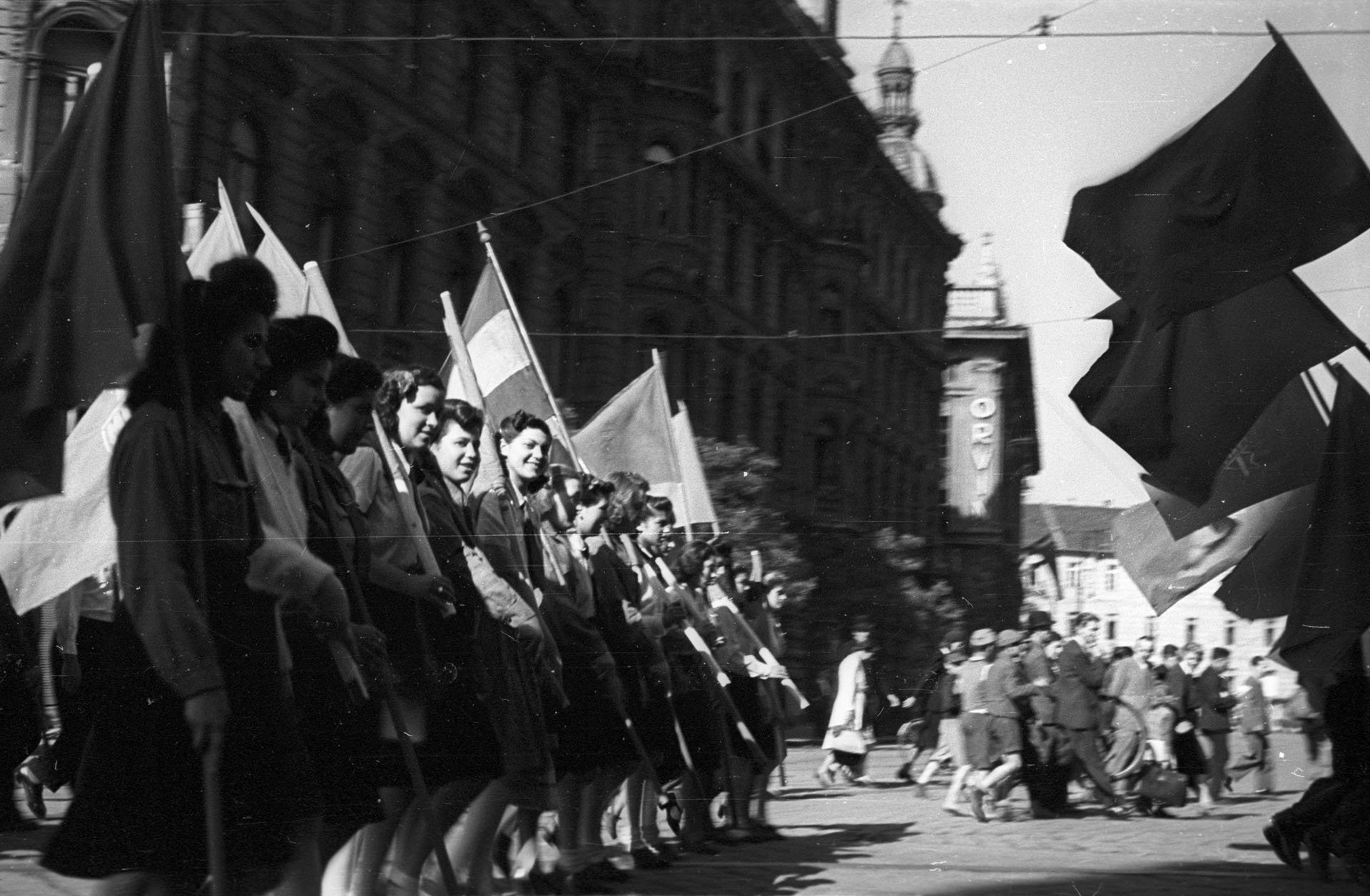 Iskolás lányok zászlókkal vonulnak (Fotó: Fortepan)