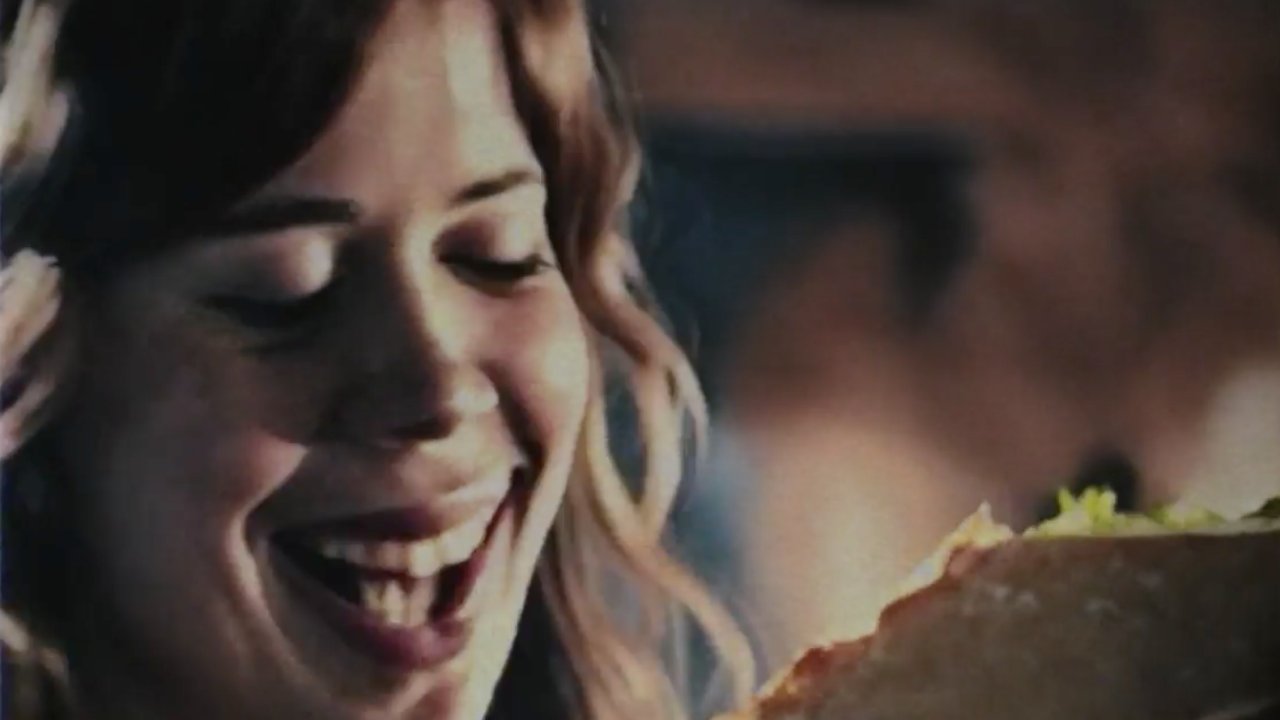 Egy nő pizzát eszik – jelenet a mesterséges intelligencia által készített pizzareklámból