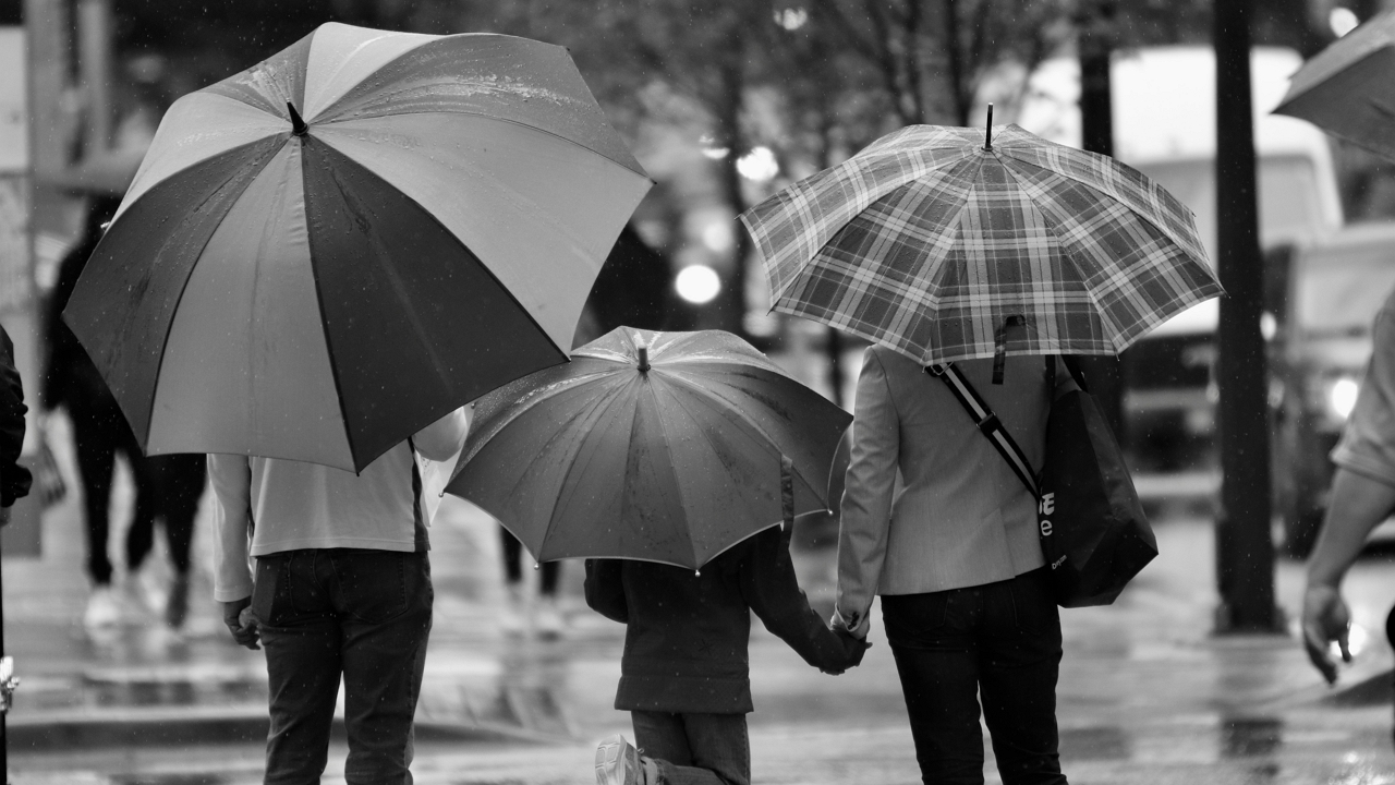 család az esőben esernyővel