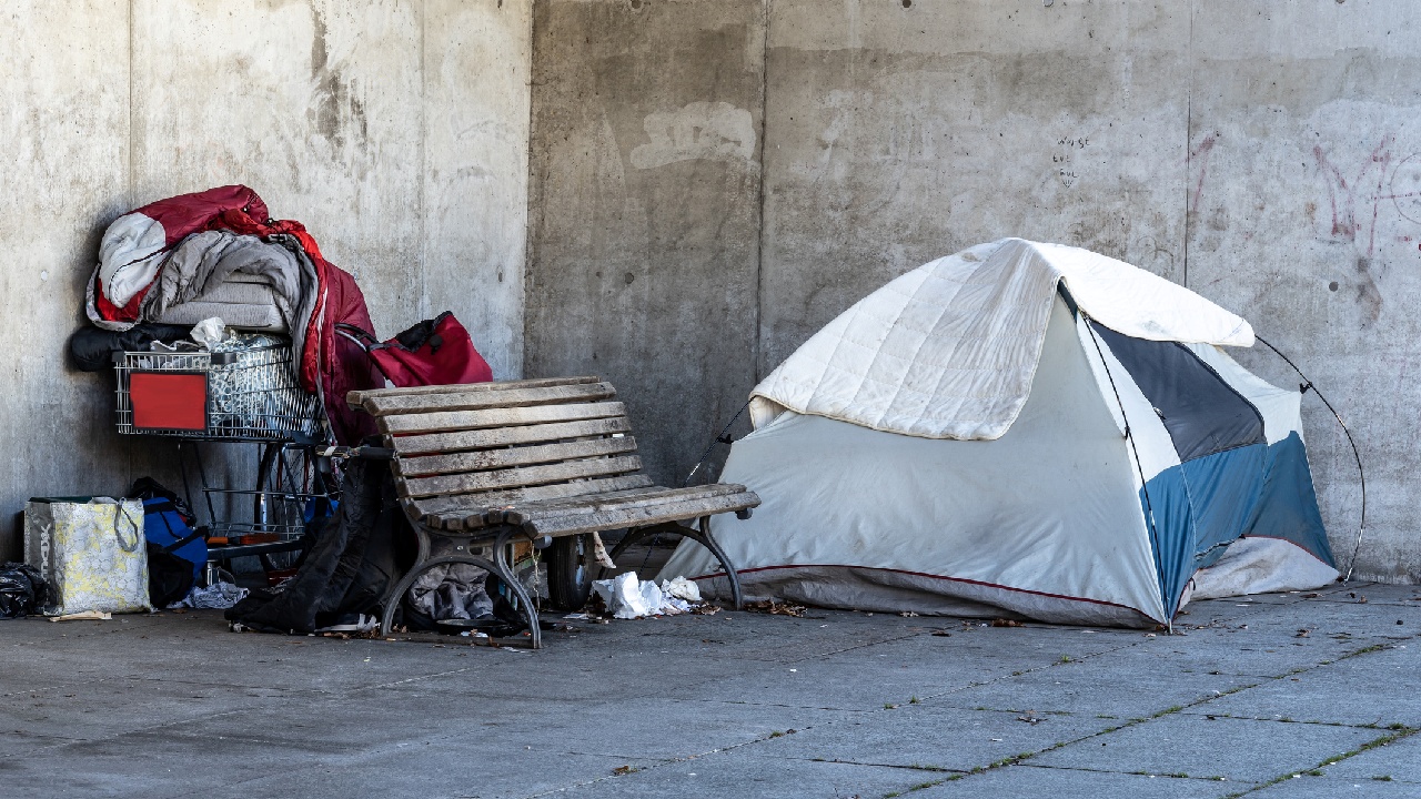 hajléktalan sátra egy pad mellett.