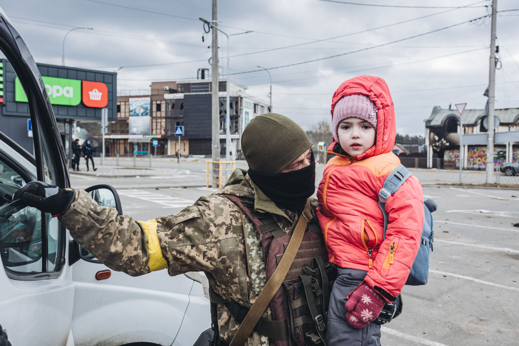 Ukrán katona evakuál egy gyereket