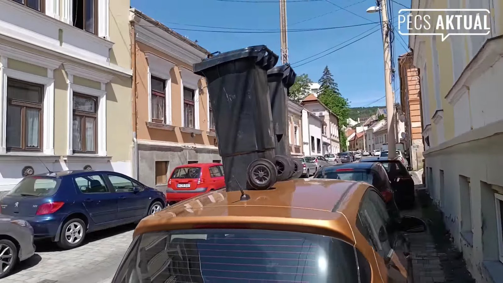 Autó tetejére pakolt két kuka Pécsen