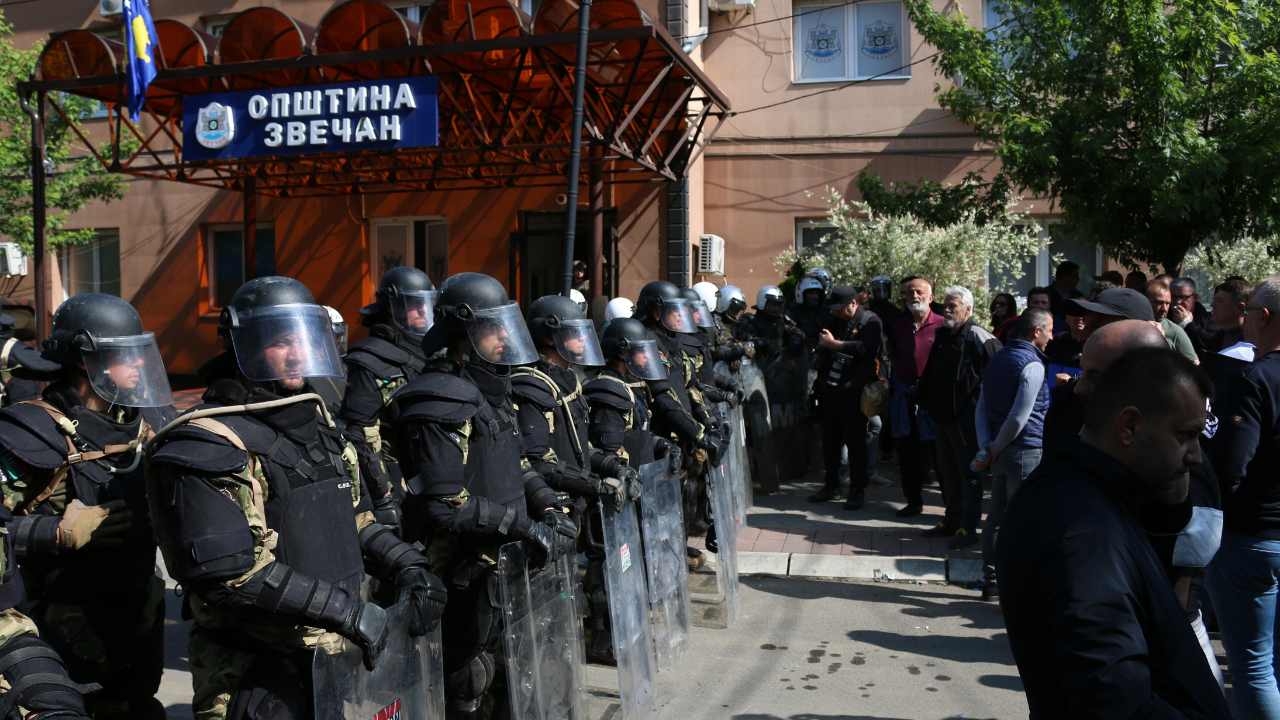 A koszovói rendőrség különleges egységei védik az önkormányzat épületét a szerb tüntetőktől az albániai új polgármester elleni akciójukon a koszovói Mitrovicában 2023. május 29-én. 
