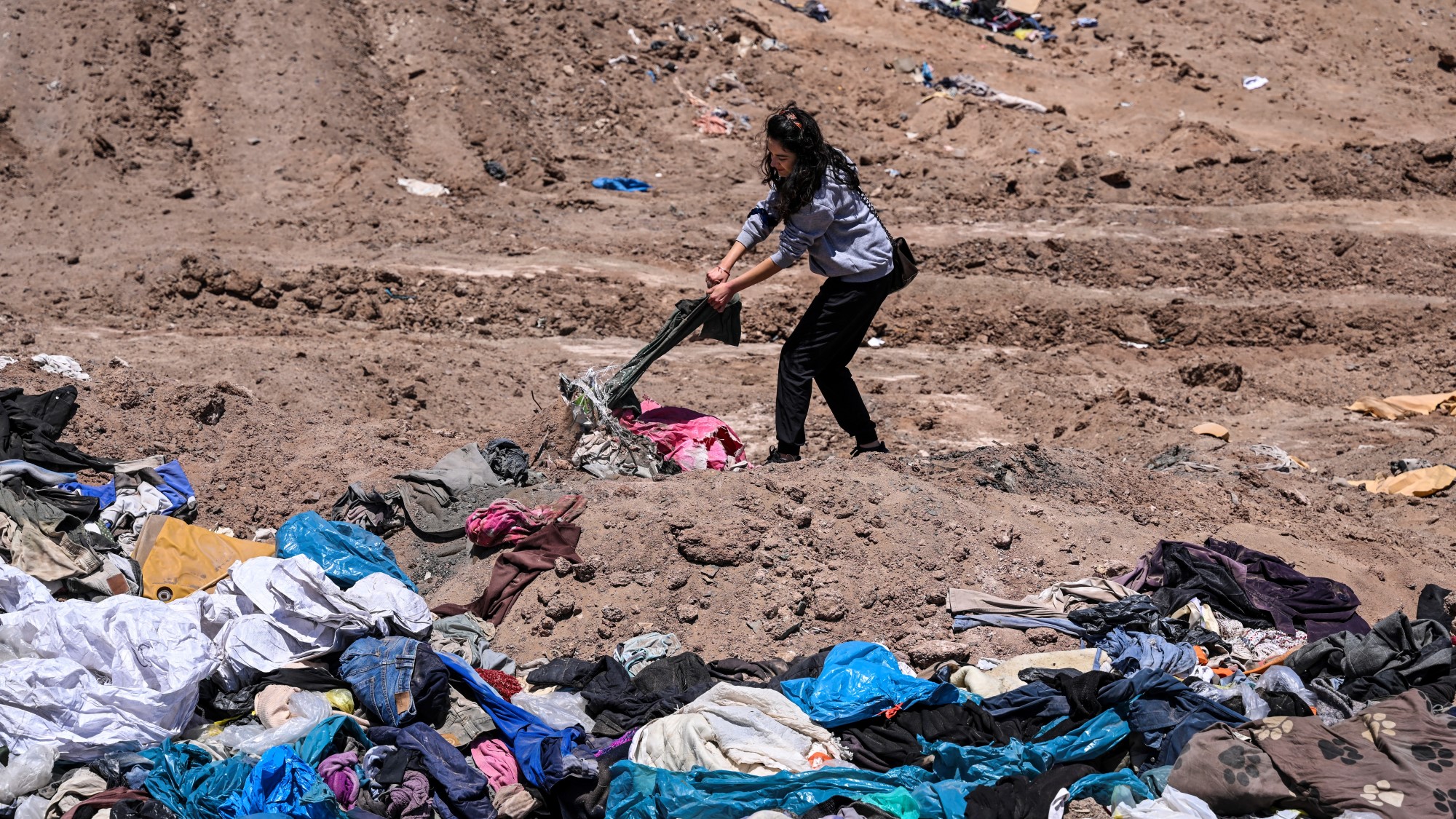 Paulina Silva ügyvédnő mutatja a sivatagba dobott ruhákat a chilei Iquique városától mintegy 10 kilométerre.