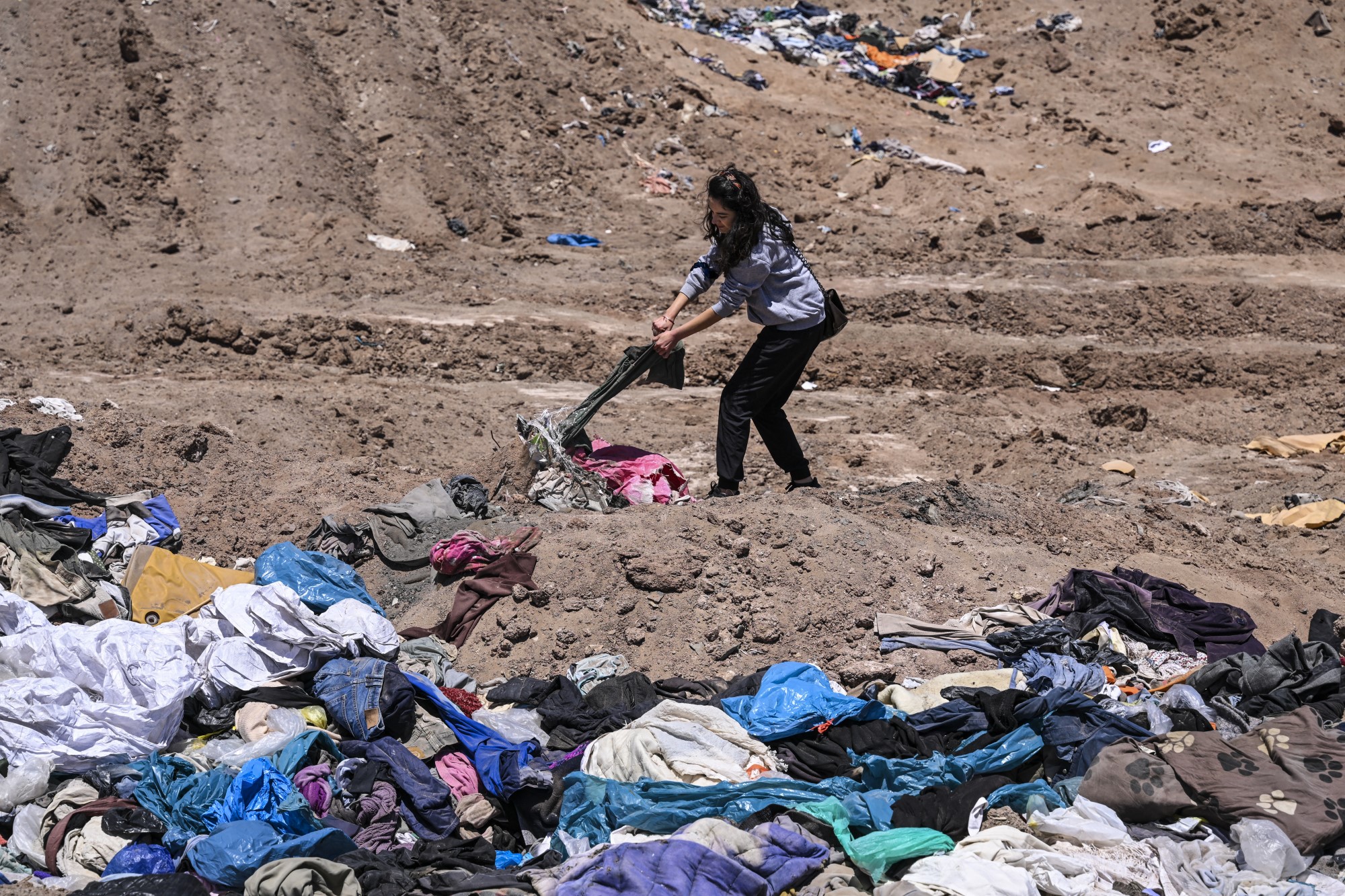 Paulina Silva ügyvédnő mutatja a sivatagba dobott ruhákat a chilei Iquique városától mintegy 10 kilométerre.