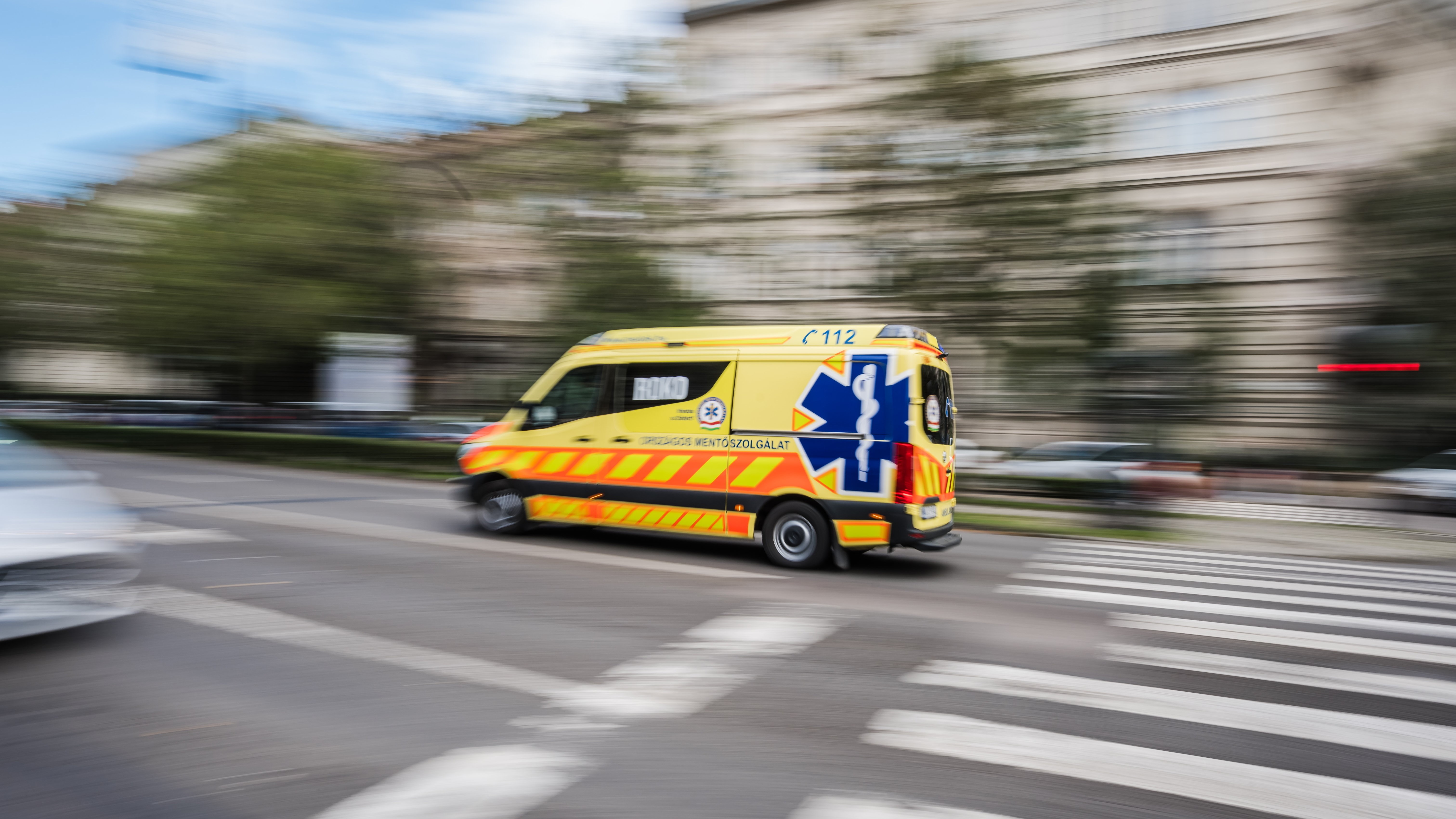 Az Országos Mentőszolgálat megkülönböztető jelzést használó mentőautója halad a fővárosi Andrássy úton