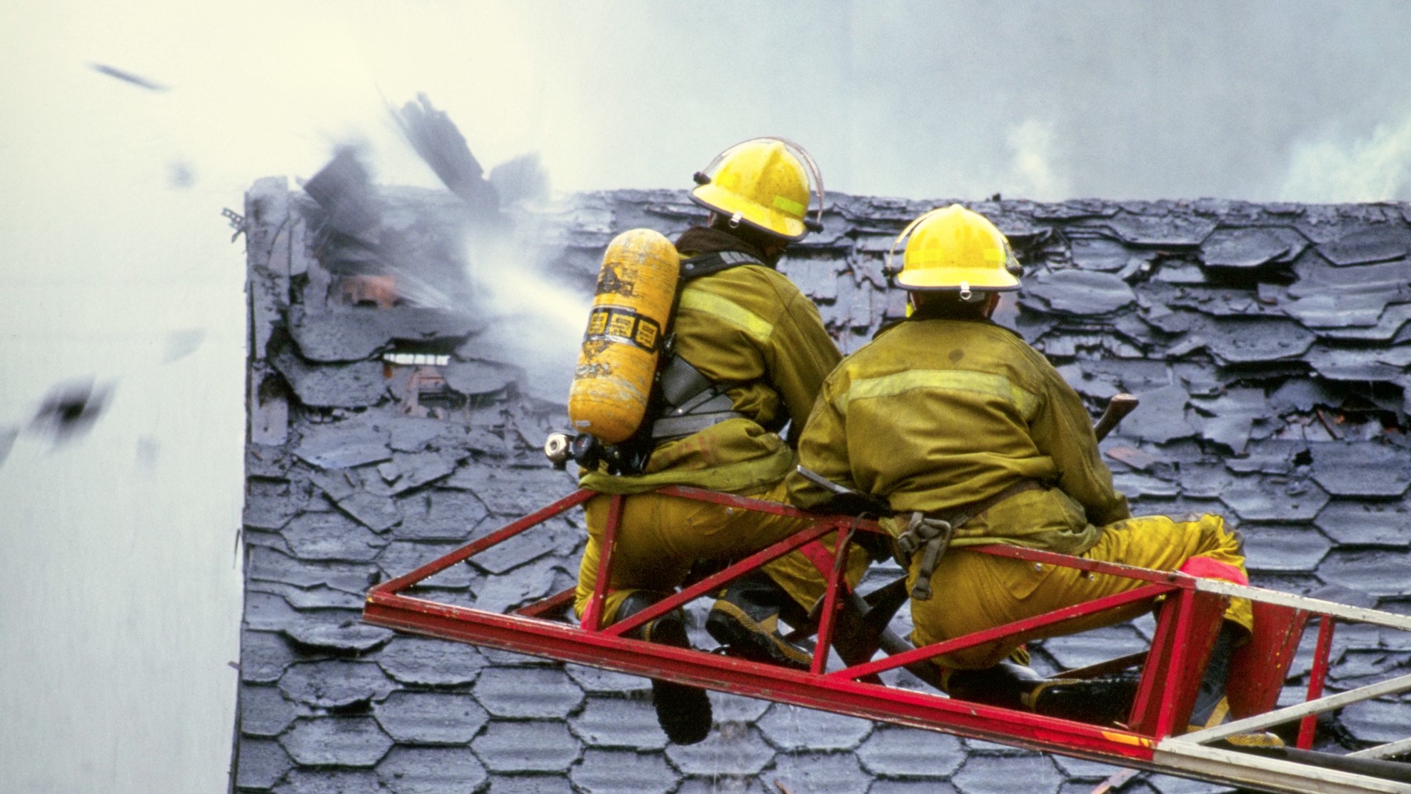 Tűzoltók egy ház tetőszerkezetét oltják