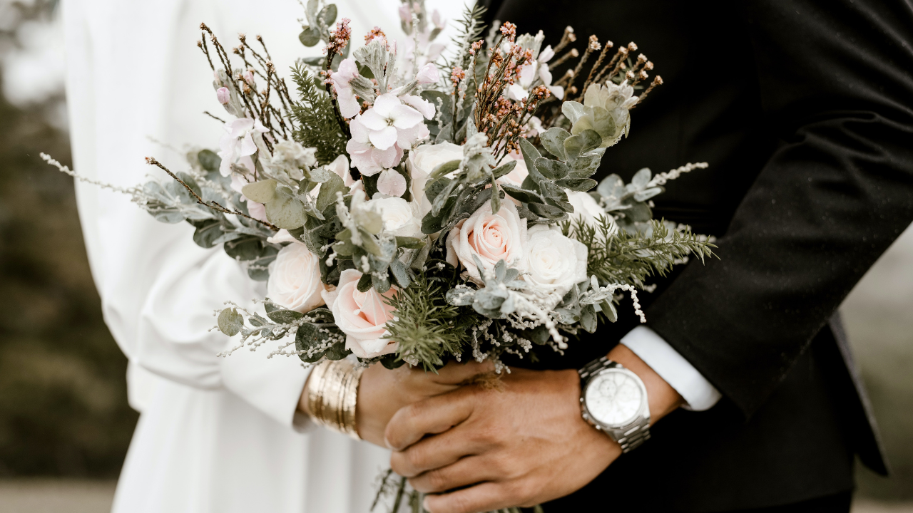 Házaspár egy virágcsokorral a kezükben
