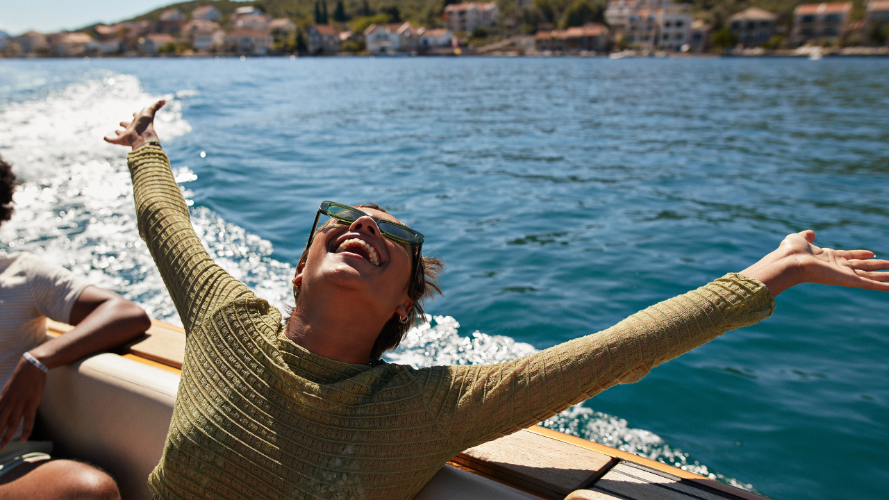 Egy nő egy hajóról élvezi a nap sugarait