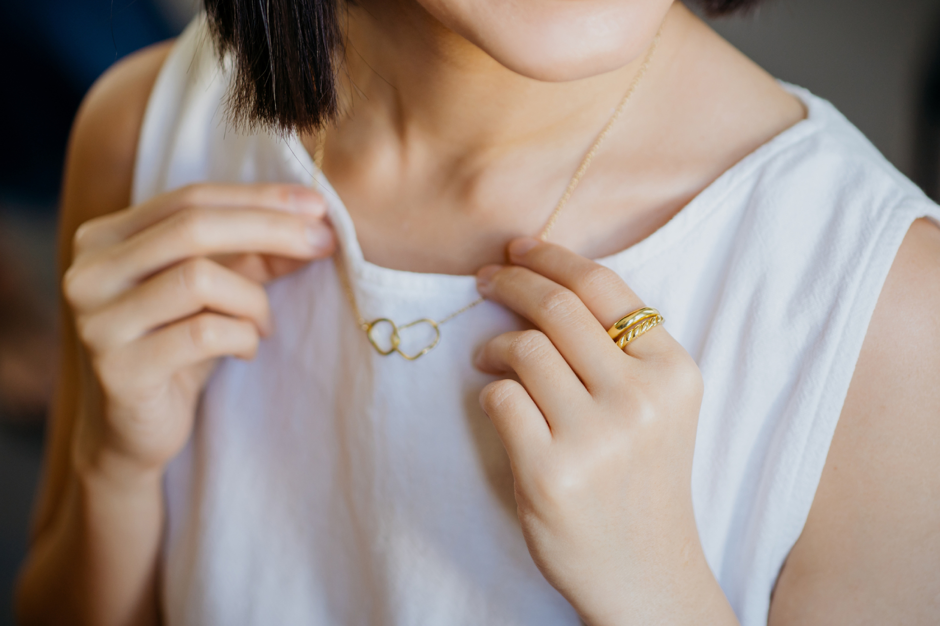 Aranyláncot és gyűrűt viselő nő.