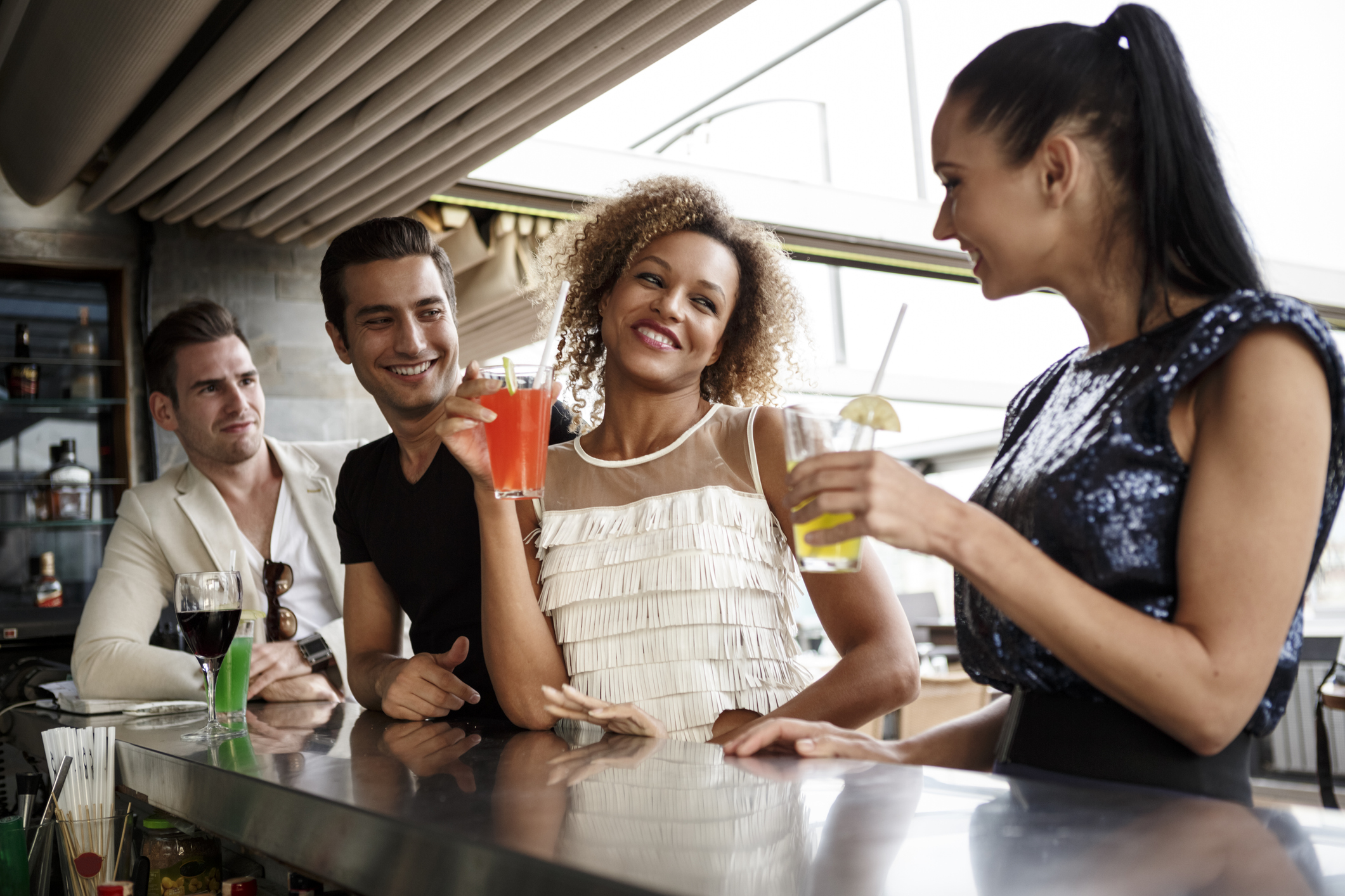 Két fiatal lény és két srác állnak egy bárpultnál, koktélt isznak és beszélgetnek.