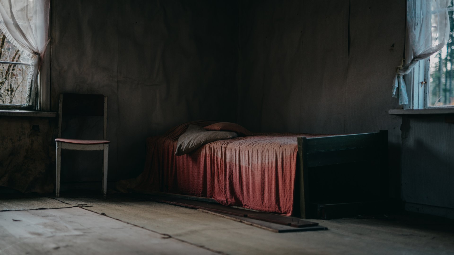 Szék és ágy egy sötét szobában