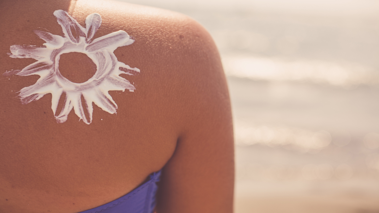 Bikinis nő hátán naptejjel rajzolt nap.
