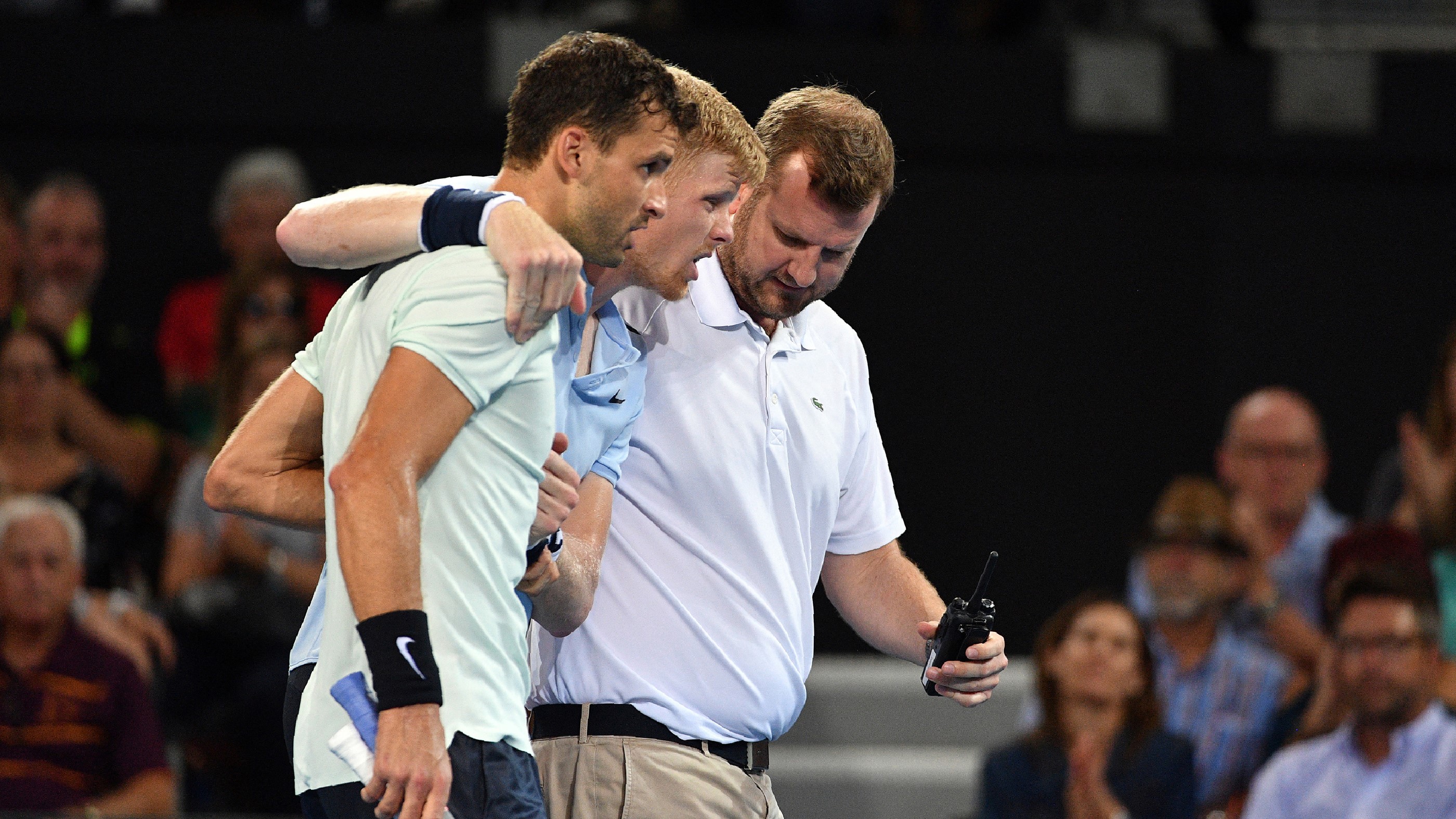 Grigor Dimitrov segít Kyle Edmundnak, miután megsérült a lába egy ausztrál teniszversenyen.