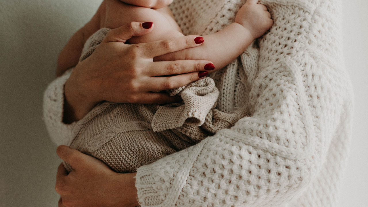 Egy édesanya a karjaiban tartja kisbabáját
