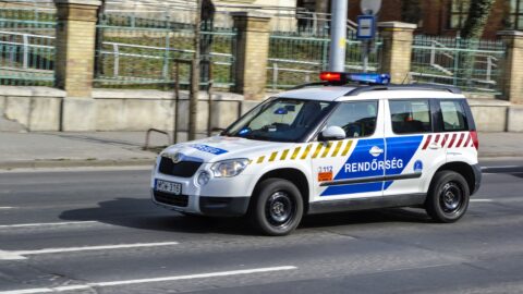 Egy szirénázó rendőrautó halad el a Magyar Honvédség Egészségügyi Központ és az Állami Egészségügyi Központ épületegyüttese előtt a főváros XIII. kerületében, a Róbert Károly körúton