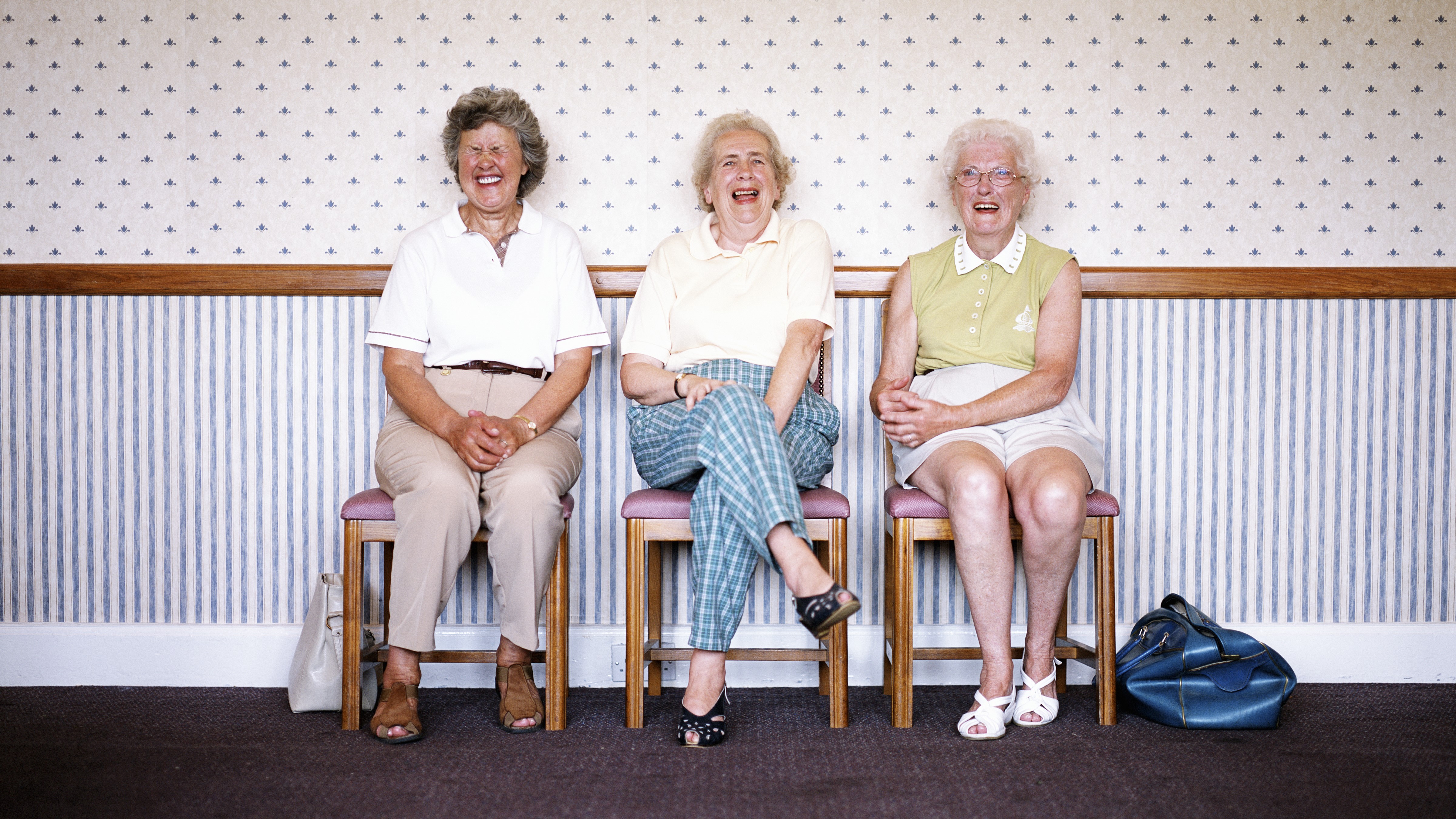 Idős nők nevetnek széken ülve
