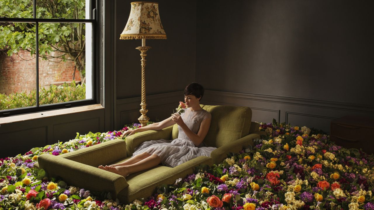 Lány fekszik virágok között