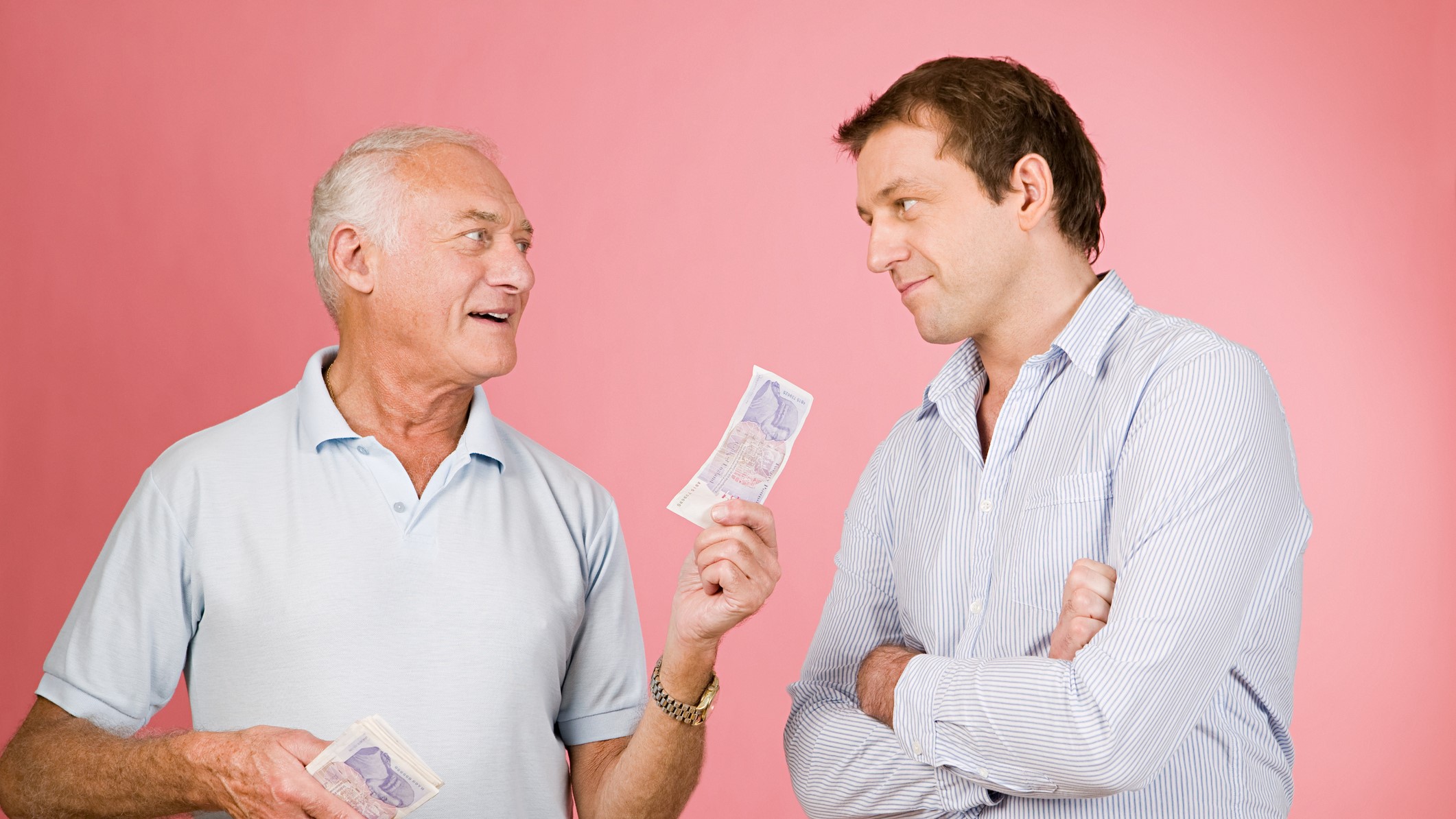 idős férfi pénzt ad egy fiatalabb férfinak