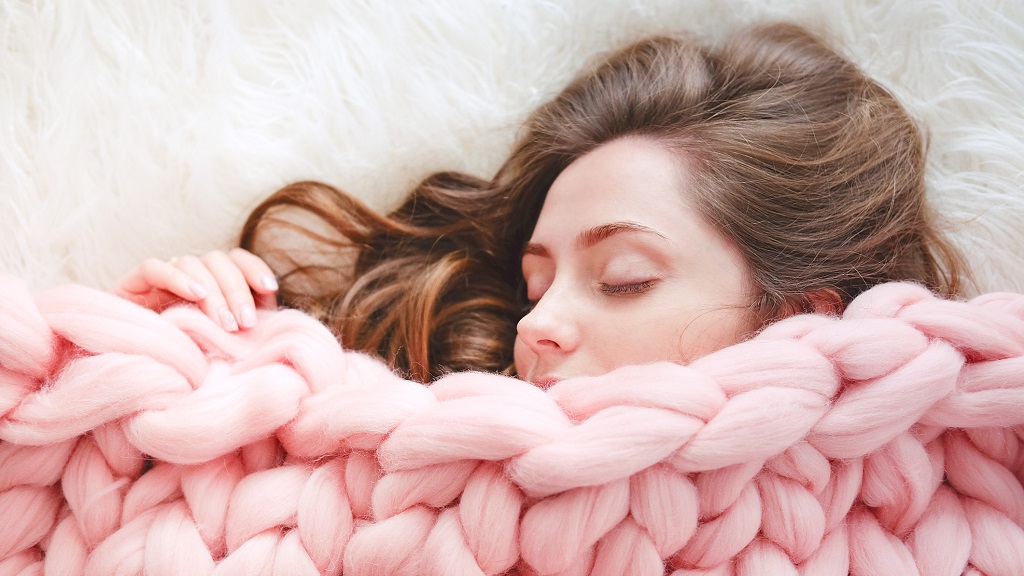Fiatal nő meleg takaróba burkolózik