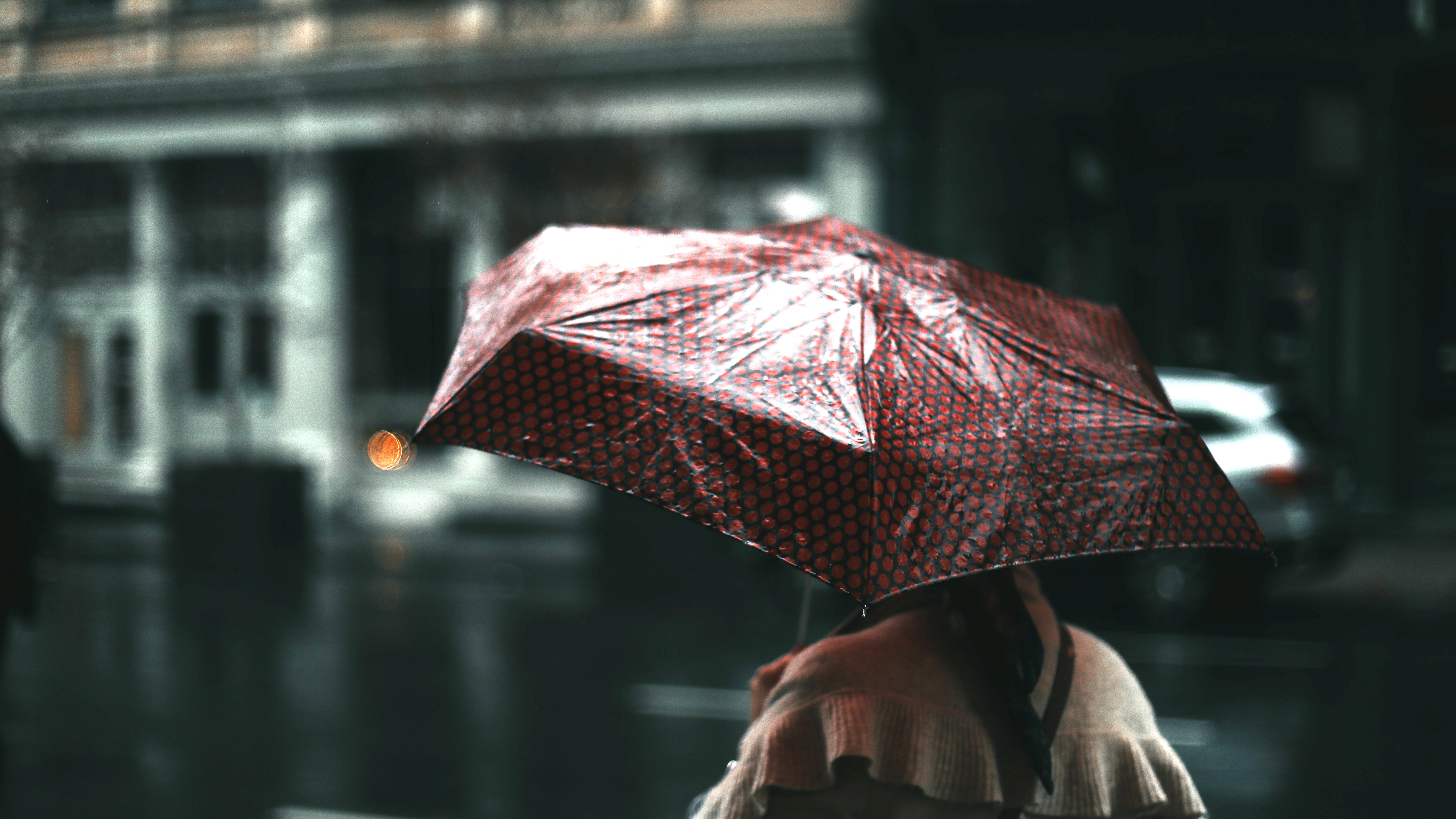 Nő esernyővel sétál