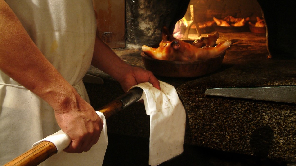 A Sobino de Botín séfje kivesz egy sült malacot a kemencéből. Ez a legnépszerűbb fogás .